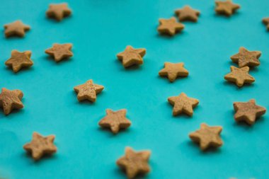 Yumuşak mavi arka planda altın yıldızlar. Kenarları bulanık. Soyutlama, gün ışığı.