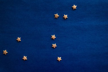 Düz mavi bir yüzeyde küçük sarı yıldızlar. Aslan Takımyıldızı, zodyak sembolü. Doğal ışıklandırma, üst görünüm.