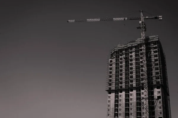 建造中的房子和空中的塔式起重机 遵守安全条例和建筑法规 黑白调 复制空格 — 图库照片