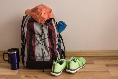 Toplanan sırt çantası, ekose, kep ve spor ayakkabıları yolculuğun başlamasını bekliyor. Yakında yaz, tatil sezonu. Yeni rota, seyahat.