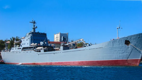 一艘灰色的大战舰在港口的路边 在导航设备上 侧视图 阳光灿烂的一天 — 图库照片