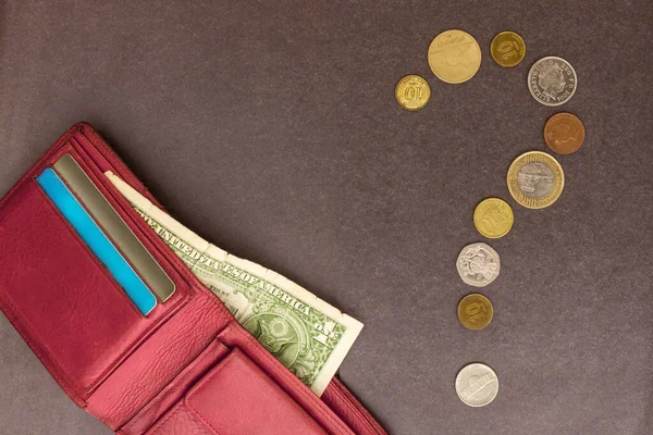 Bozuklukların dışına bir soru işareti konur. Kırmızı bir çantada, bir dolar. Param yok, ne yapayım? Gri arkaplan, üst görünüm.