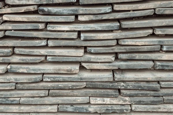 The tile is stacked. Narrow horizontal lines, staggered. Dirty, dusty surface. Gray tones.