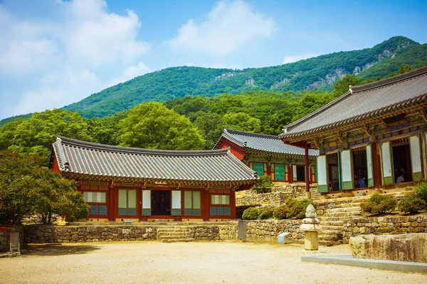 The territory of the temple in South Korea, traditional buildings, a stone courtyard. Away green mountains, blue sky. Bright sunny day.