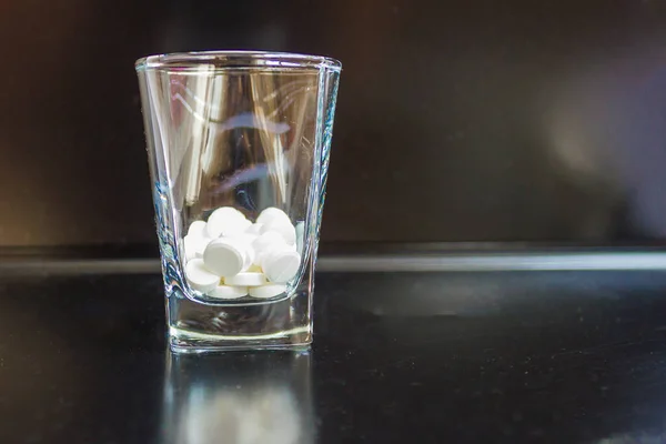 Glass White Tablets Glossy Black Table Background Blurred Daylight — Stock Photo, Image