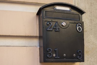 Binanın ışık duvarında bir posta kutusu var. Mektuplar almak, haber, endişe, endişe, umut, bilgi eksikliği. Gün ışığı.