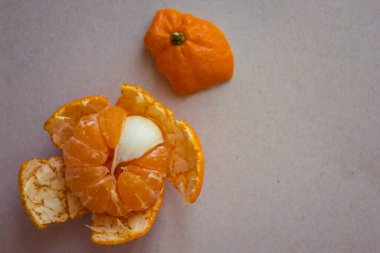 Mandalinadaki tüm lobulalar tatlı, biri sarımsaklı, acı. Merhemde bir sinek. Işık arkaplan, üst görünüm.