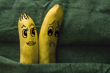 Impotence, lack of attraction to his wife, sexual coldness. Two bananas, spouses, in a family bed. The woman flirts, her husband turns away. The picture is made by the author. clipart