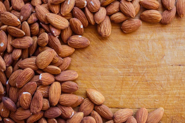 Almond kernels, nuts on a natural wooden surface. Vegetarian cuisine, diet, fasting, proper nutrition. A source of protein and vitamins. Daylight, top view.