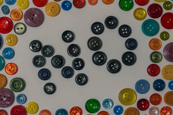 Among the colored, bright buttons for clothes, there are black in the middle. Life in black, boredom, depression.