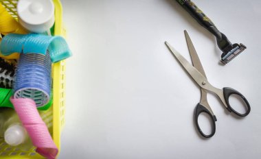 Çöp kutusunda, taraklarda, bigudilerde, şampuanlarda. Sıradaki makas ve tıraş makinesi. Basit bir hareket, radikal bir karar. Hafif arkaplan, vignetting, üst görünüm.