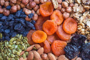 Kurutulmuş kayısılar, farklı türde fındıklar ve kuru üzümler. Faydalı, basit, tatmin edici, lezzetli yemekler. Etsiz menü, sebze proteini kaynakları. Üst manzara, gün ışığı..