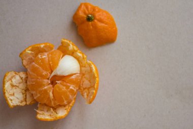 Portakal rengi mandalinayla, bir dilim sarımsak. Tatlı olarak acı, merhemde bir sinek, bir yabancı, bir yabancı. Üst görünüm, hafif arkaplan.