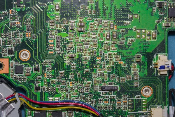 Sensors, fuses, wires on the green panel. Computer repair, component replacement. Complex scheme, interaction. View from above.