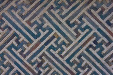 Süslü, dekoratif bir beton duvar. Mavi çizgiler, gamalı haç sembolü. Yetenekli iş..