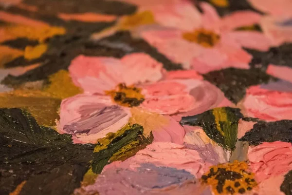 Fragment of still life drawing with oil paints. Flowers with pink petals, large strokes. The background is blurred.