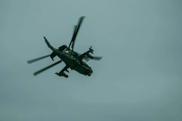 Helicopter flight in the sky. Military aircraft, exercises. Cloudy day. View from below.