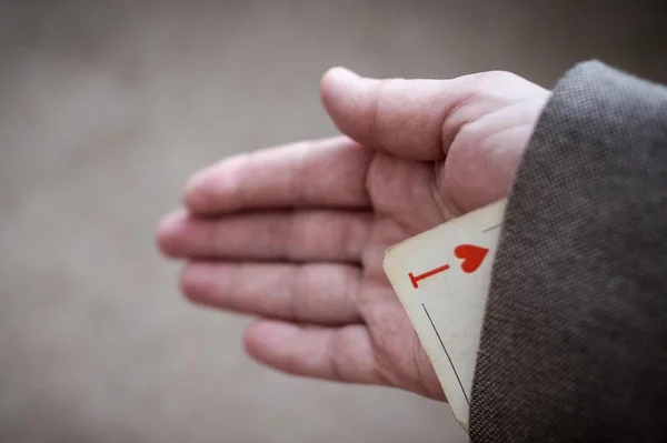 Hidden ace, large playing card, trump card. The game is not by the rules, cheating. Ace in focus, the background is blurred. Vignetting, copy space.