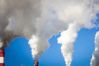 Endüstriyel borular kalın duman üretir. Parlak mavi gökyüzü, beyaz emisyonlar. Ekoloji, sorunlar, küresel ısınma.