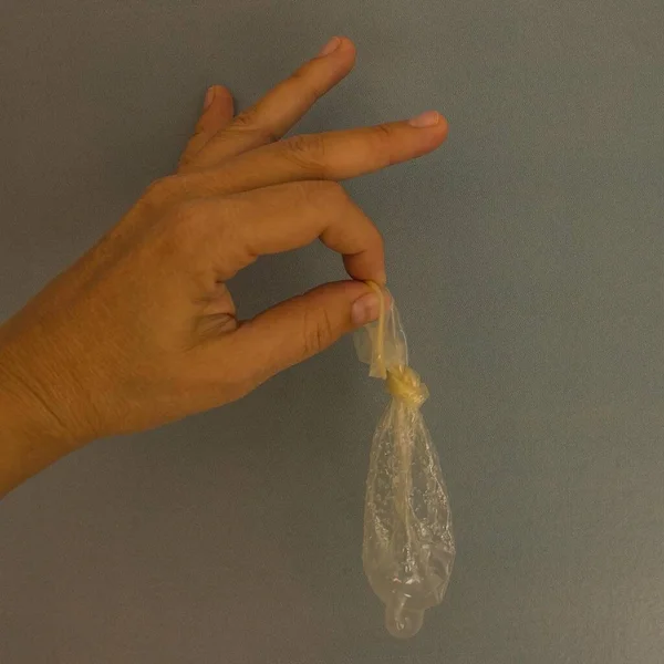 コンドームを持ってる 結果の欠如 状況の制御 信頼性の保証 灰色の背景 — ストック写真
