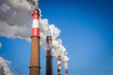 Tüten bacalar, fabrika, endüstriyel fabrika. Kötü ekoloji, hava kirliliği. Parlak mavi gökyüzü, boşluğu kopyala.