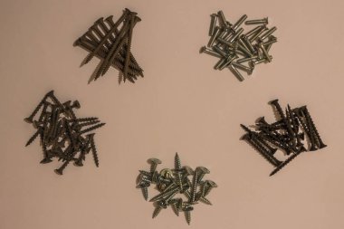 Hafif bir arka planda çeşitli vidalar ve cıvatalar var. Marangozluk, inşaat işleri, evde küçük erkek işleri..