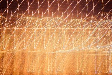 Gece şehrinin ışıkları, aydınlanma. Paralel izler, ışık izleri. Altın, sarı, turuncu renkler. Vignetleme.