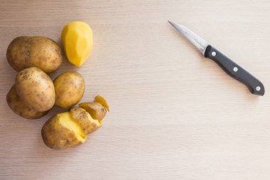 Işık panosunda bıçak ve patates yumrusu. Doğal ürün, sarı kalite. Patatesten ev yapımı yemekler, geleneksel yemekler..