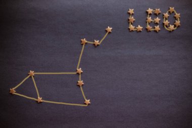 Sarı yıldızlar, leylak arkaplanda Aslan takımyıldızının şeması. Astroloji, burcun işareti. Yukarıdan bak. Resim yazar tarafından yapılmıştır..