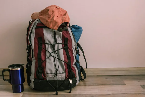 Tourist equipment is prepared for the hike, the backpack is assembled. Preparing for a trip, hike, summer vacation. Light background, daylight.