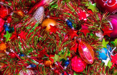 Parlak, şenlikli bir arka plan. Dekoratif toplar, yıldızlar, şişlikler, boncuklar, biblolar. Yılbaşını bekliyor, Noel ağacını süslüyor..