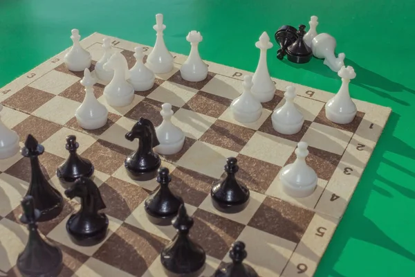 A game is played on the chessboard. Part of the figures lie next to the board. Black horse in center field. Complex position, combination. Consider the next move.