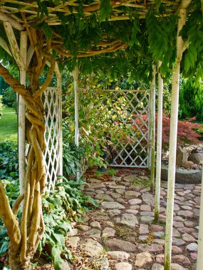 Pergola gazebo in a beautiful garden clipart