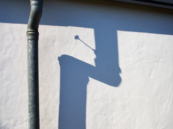 Beyaz bir duvar karşı metal pis su borusu — Stok fotoğraf