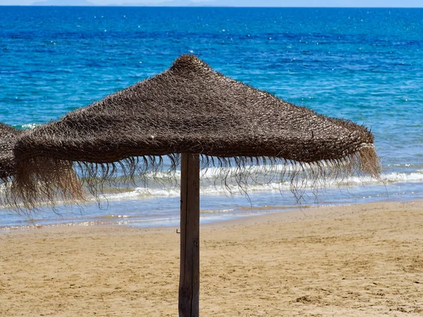 Зонтик на тропическом пляже — стоковое фото