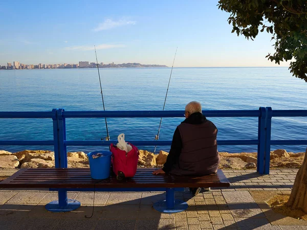 Anciano pescando junto al océano —  Fotos de Stock
