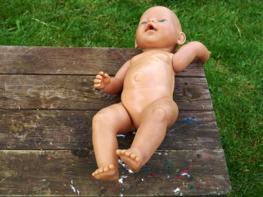 Masadaki eski kirli oyuncak bebek.