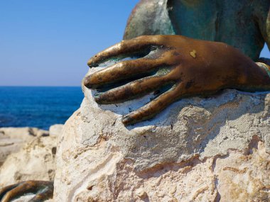 Yiota Ioannidou 'nun Afrodit Sol Alter' e hürmetlerini sunan genç kadın heykeli, arkeoloji parkı ve Kıbrıs Rum Kesimi 'nin bir kısmı olan Paphos Kıbrıs Temmuz 2019' daki açık hava müzesini çevreleyen ünlü turistik bir sahil yolu kapsamında yer alıyor.