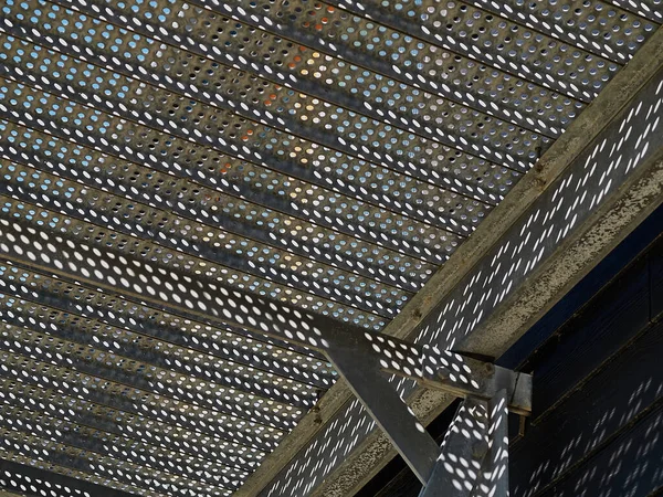 Metal stairs staircase made with small round holes for emergency entry exit with clear blue sky background