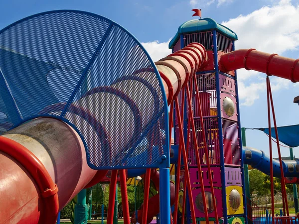 街の公園で異なる方向にいくつかのスライドを持つカラフルな創造的な遊び場 — ストック写真