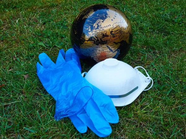 The world after the Coronavirus Global Pandemic - Covid-19 - A globe facing Europe and Africa with protection mask and gloves taken off