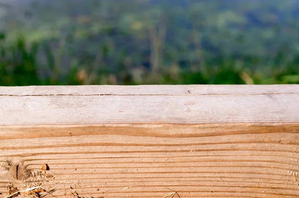 Escritorio de madera con fondo borroso de paisaje con hierba . — Foto de Stock