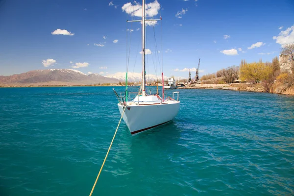 Yate en el muelle en las aguas azules del lago Issyk-Kul — Foto de Stock