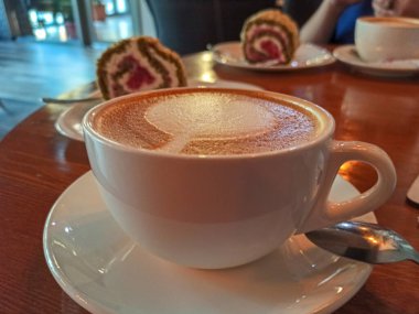 Kahve dükkanındaki bir masanın üzerinde bir fincan kahve. yiyecek arka planı