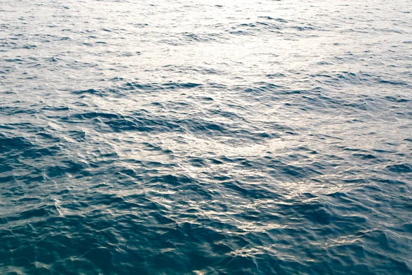 Struttura dell'acqua trasparente in blu. Sullo sfondo dell'oceano e del mare retroilluminato dal sole . — Foto Stock