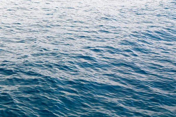 Struttura dell'acqua trasparente in blu. Sullo sfondo dell'oceano e del mare retroilluminato dal sole . — Foto Stock