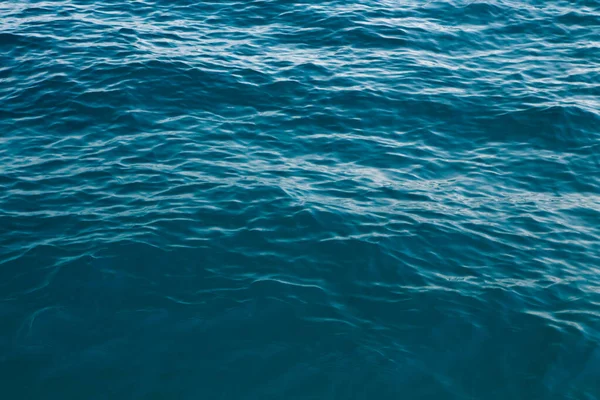 Чистая текстура воды в синем. Фон океана и моря подсвеченный солнцем . — стоковое фото