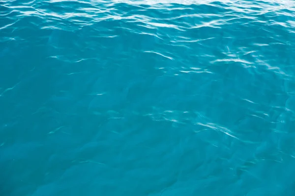 Чистая текстура воды в синем. Фон океана и моря подсвеченный солнцем . — стоковое фото