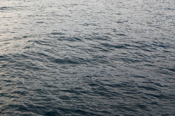 Textura de agua clara en azul. Fondo del océano y el mar retroiluminado por el sol . —  Fotos de Stock