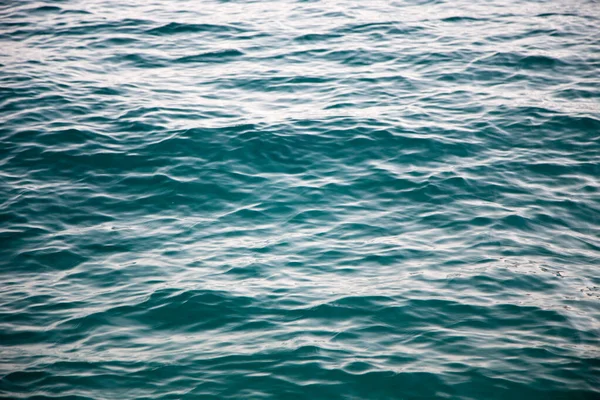 Jasna tekstura wody w kolorze niebieskim. Tło oceanu i morza podświetlone słońcem. — Zdjęcie stockowe